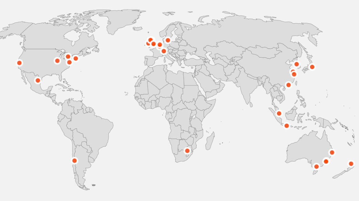 A grey map of the world with orange pins.